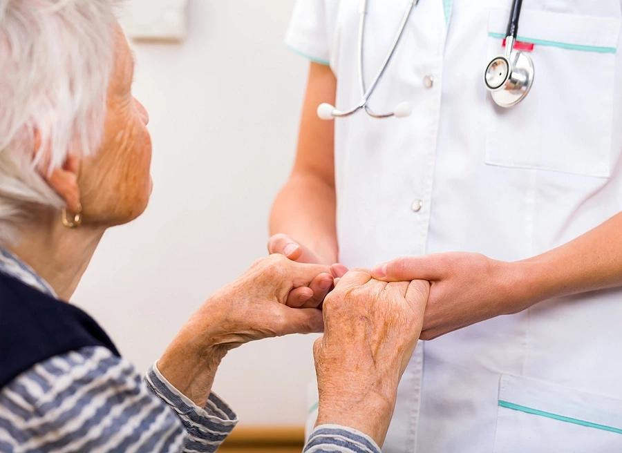 Old+ woman holding hands with nurse