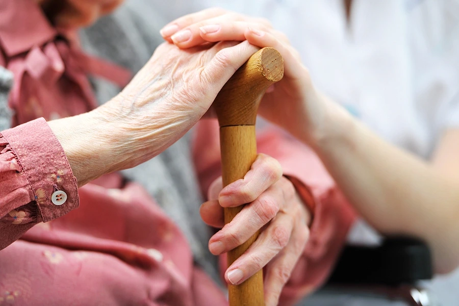 Senior woman holding care giver's hands